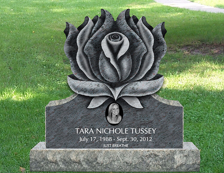 Granite monument topped by a large carved rose in bloom, with a porcelain portrait