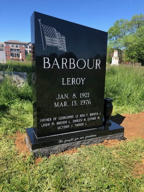 Black granite upright monument etched with an American flag, newly installed